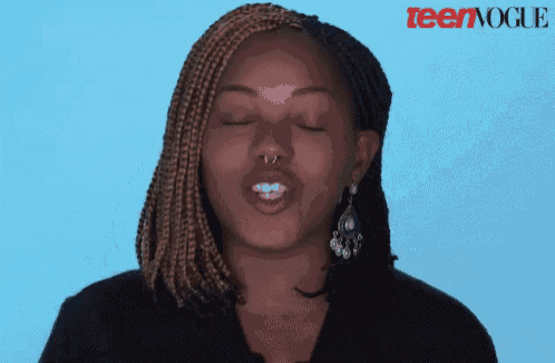 a woman making a funny face in front of a blue background with teenvogue written on it