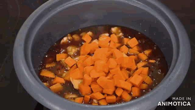 a bowl of carrots in a sauce with the words made in animotica on the bottom