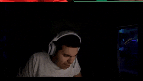 a man wearing headphones is sitting in front of a computer screen