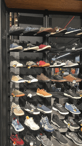 a display of shoes in a store with a yellow tag that says ' salomon ' on it