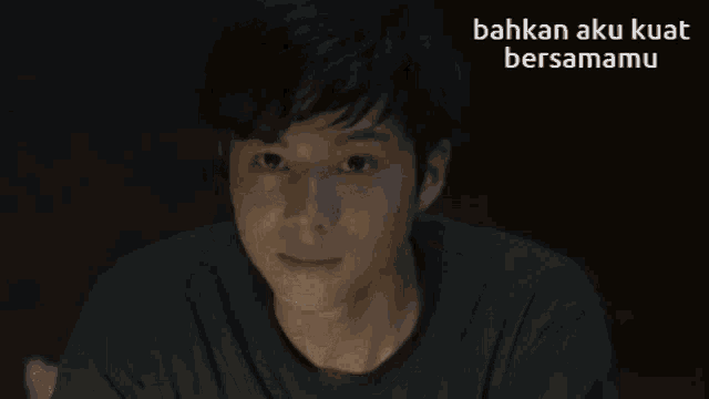 a man in a dark room with the words bahkan aku kuat bersamamu above him