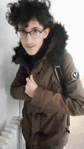 a young man wearing glasses and a parka with a fur hood