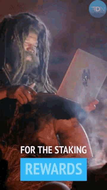 a man with dreadlocks is using a laptop and the words for the staking rewards are below him