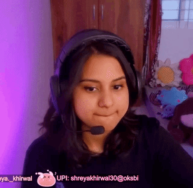 a woman wearing headphones and a microphone with the username upi on the bottom