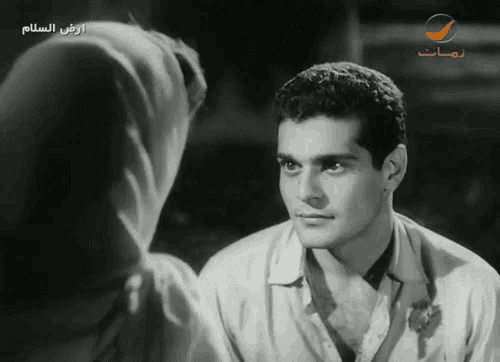 a black and white photo of a man and a woman with arabic writing on the bottom