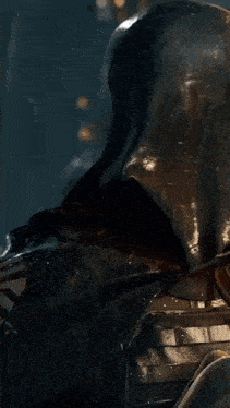 a grim reaper with a hood covering his face holds a knife to his mouth