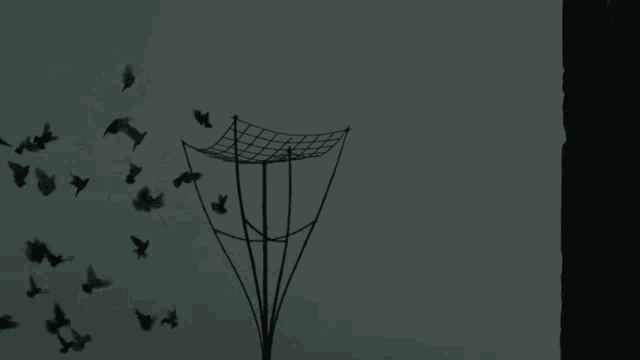 a flock of birds flying around a pole with the letter f visible