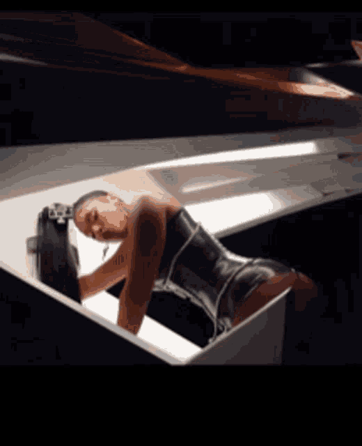 a woman in a corset is laying on a piano