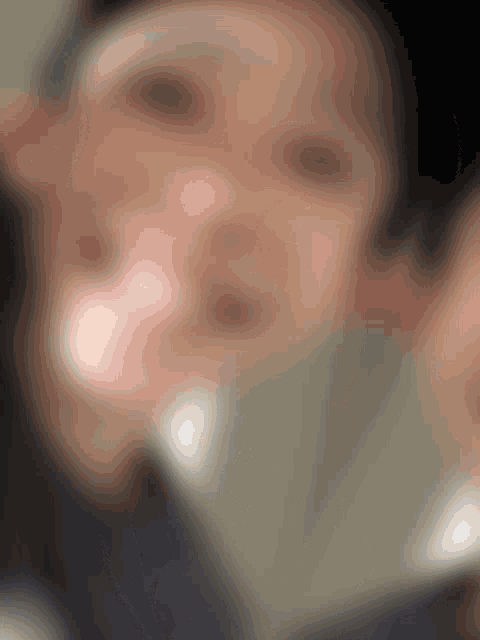 a blurry picture of a person 's face with a blurred background .