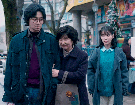 a man and two women are walking down the street