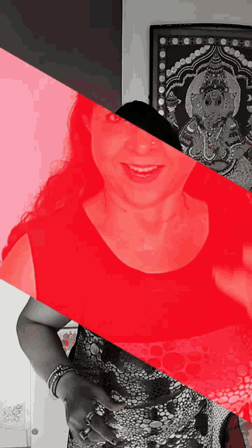 a woman in a black and white dress is smiling in front of a picture
