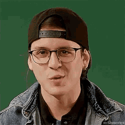 a young man wearing glasses and a baseball cap is making a face .