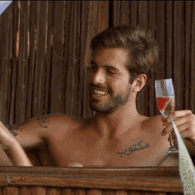 a shirtless man is holding a glass of wine and says " eu confesso " in the corner