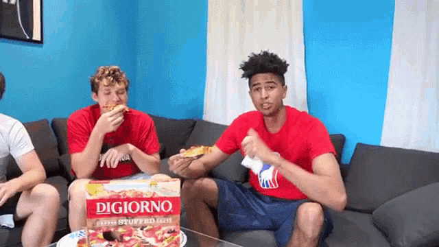 a group of young men are sitting on a couch eating pizza from a box that says digiorno