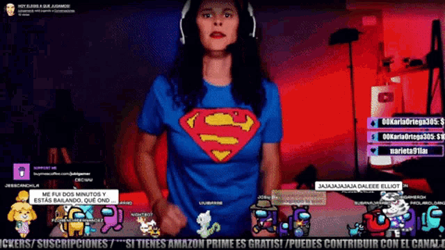 a woman wearing a blue superman shirt stands in front of a red background