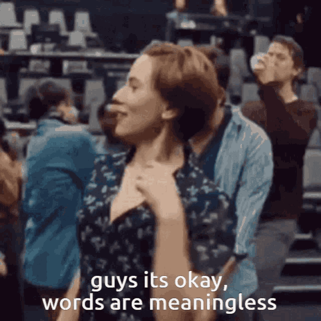 a woman dancing in a crowd with the words " guys it 's okay words are meaningless " below her