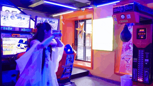 a woman playing a video game with a dragon punch machine