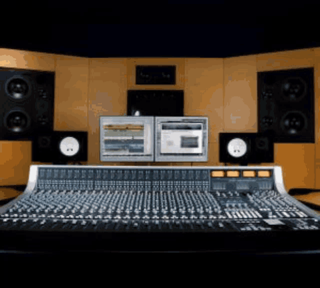 a recording studio with a mixer , monitors , and speakers