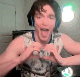 a man is wearing headphones and making a heart shape with his hands .