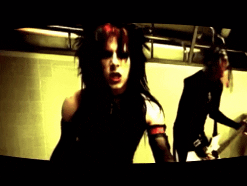 a woman with red hair is standing next to a man with a guitar