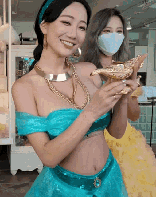 a woman in a blue dress is holding a lamp and smiling