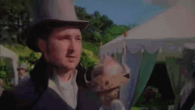 a man in a top hat is holding a hat