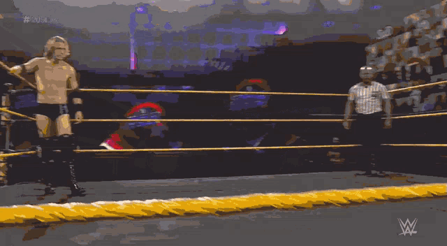 a man in a wrestling ring with a referee behind him and # 20 on the screen