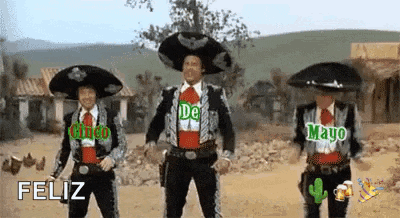three men in mariachi costumes are dancing in a desert while wearing sombrero hats .