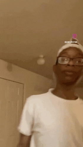 a man wearing glasses and a white shirt with the word amourstan on the bottom right