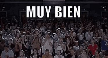 a large crowd of people are watching a movie and the words muy bien are on the screen