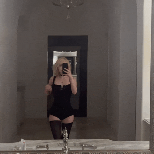 a woman taking a picture of herself in the mirror