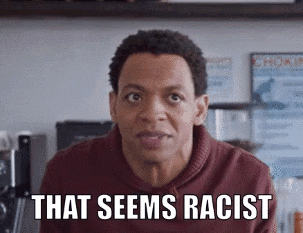 a man in a red sweater is making a funny face and says `` that seems racist '' .