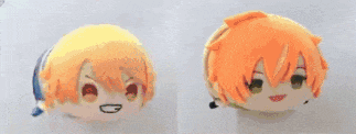 two stuffed animals with orange hair are laying on a table