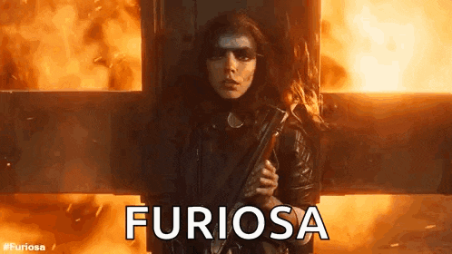 a woman is holding a gun in front of a fire and the word furiosa is written on the screen .