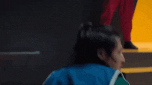 a man in a blue basketball jersey is standing on a set of stairs and looking at the camera .