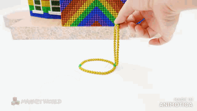 a bracelet made of magnet beads is being held by a person