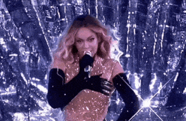 a woman is singing into a microphone in front of a purple background .