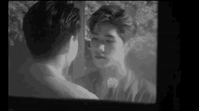 two men are looking at each other in a black and white photo .