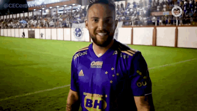 a man wearing a purple shirt with bh on the front