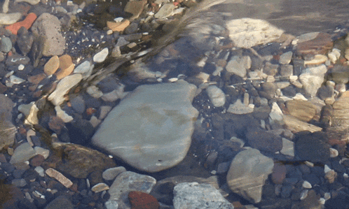 a large rock sits in the middle of a river