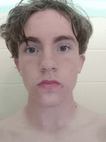 a close up of a young man 's face with blue eyes