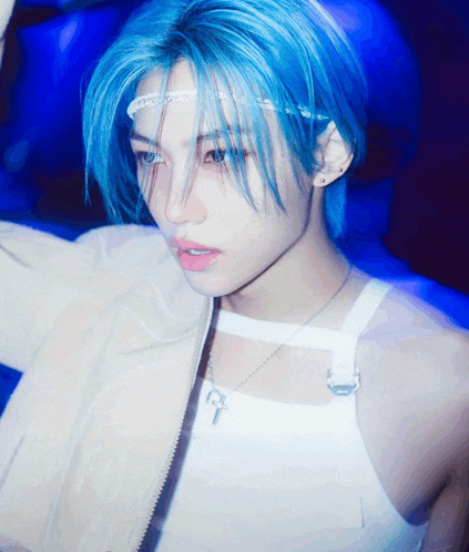 a person with blue hair wearing a white tank top
