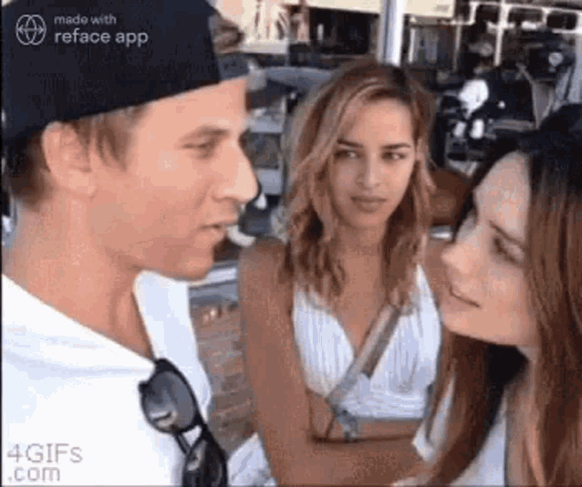 a man and two women are standing next to each other and talking .