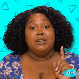 a woman with curly hair is making a funny face and pointing her finger