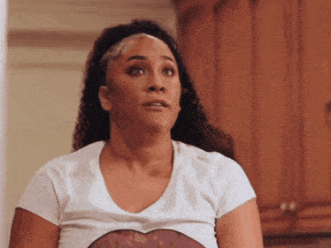 a woman with curly hair wearing a white t-shirt with a heart on it