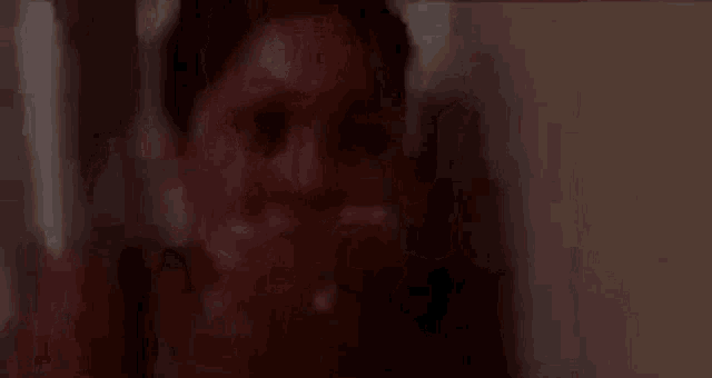 a close up of a person covering their face with their hand .