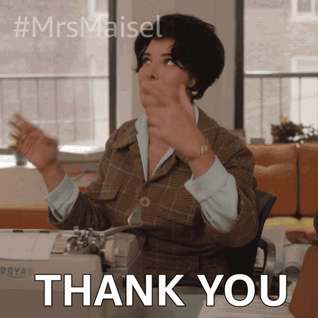 a woman sitting at a desk giving a thumbs up with the words thank you below her