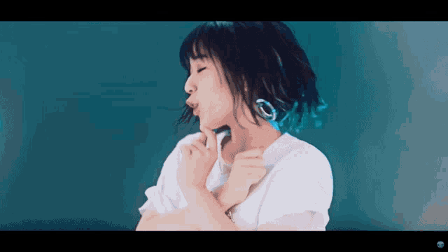 a woman with blue hair and a white shirt is making a funny face