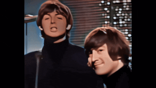two men singing into microphones in front of a building