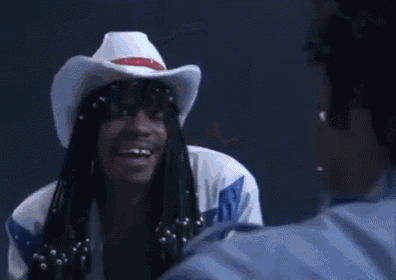 a man wearing a cowboy hat is talking to another man .